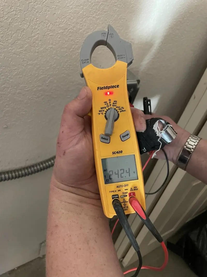 Voltage testing with clamp meter during Outlet Installation in Brandon